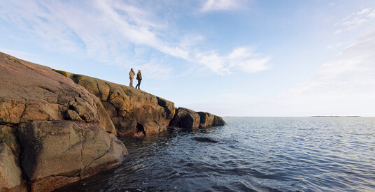Two people standing on a beach cliff