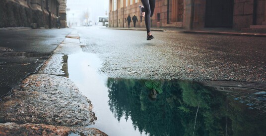 A woman running on a street water on it