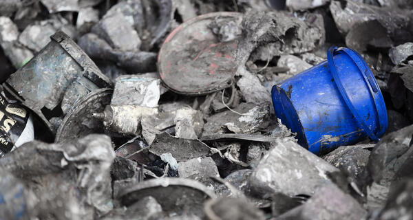 A blue plastic bucket in a pile of waste